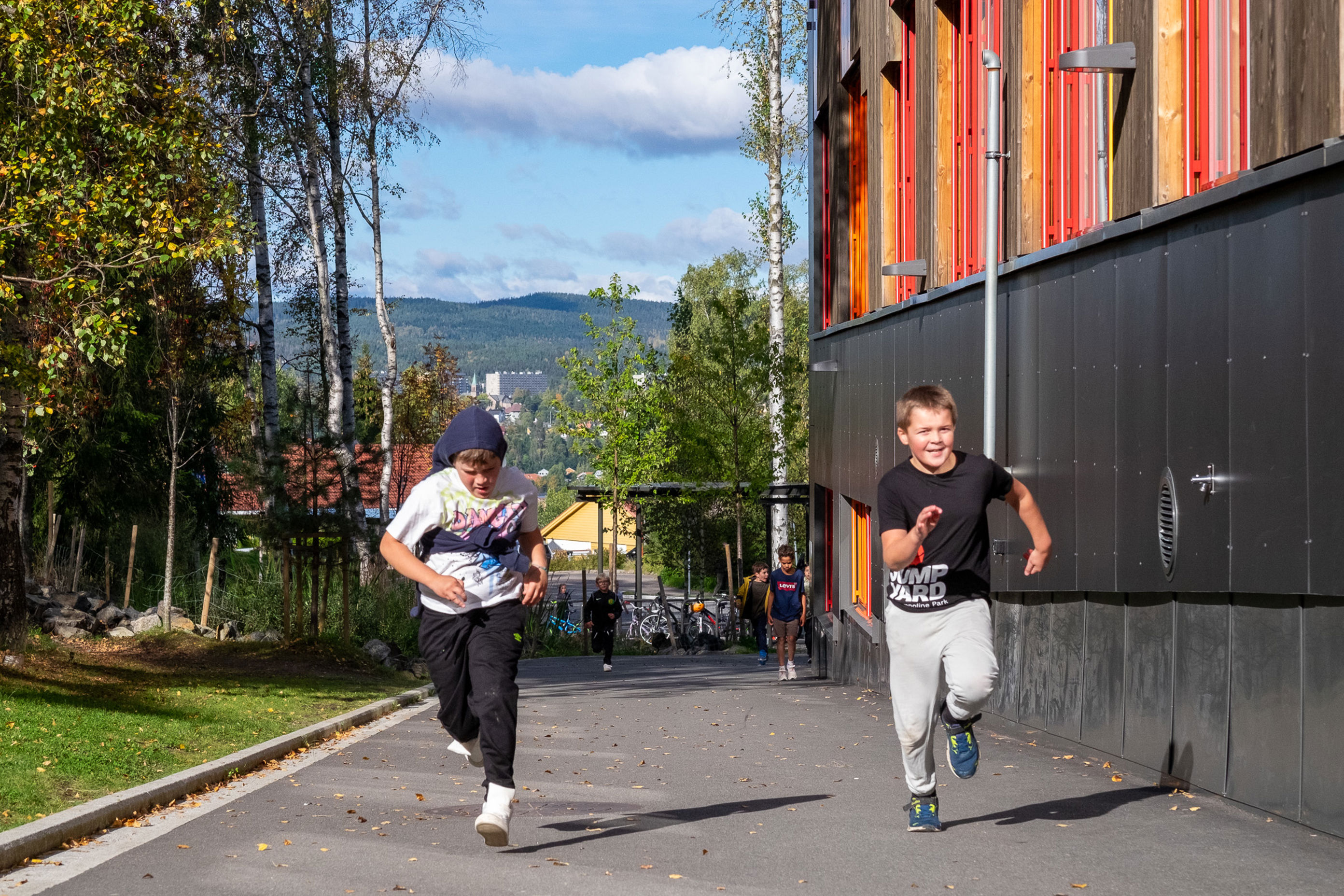 et par barner som løper på et fortau ved en bygning