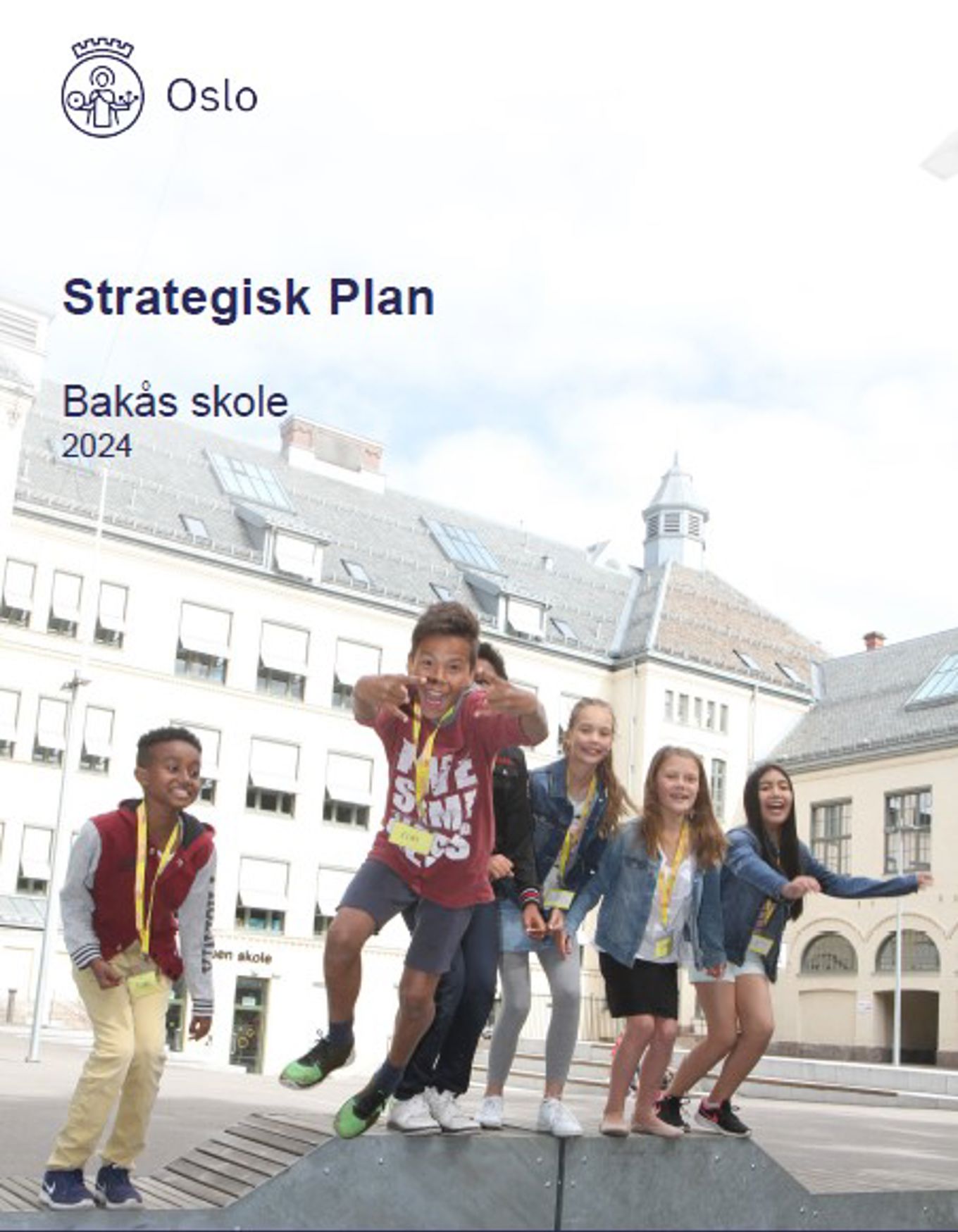 En gruppe mennesker som poserer for et bilde foran en skole bygning